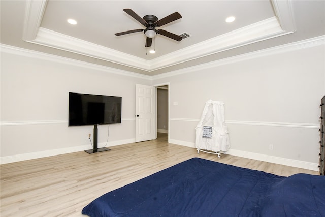 unfurnished bedroom featuring ornamental molding, ceiling fan, wood-type flooring, and a raised ceiling