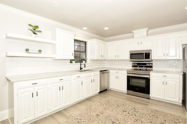 kitchen featuring white cabinets, appliances with stainless steel finishes, light hardwood / wood-style floors, and tasteful backsplash