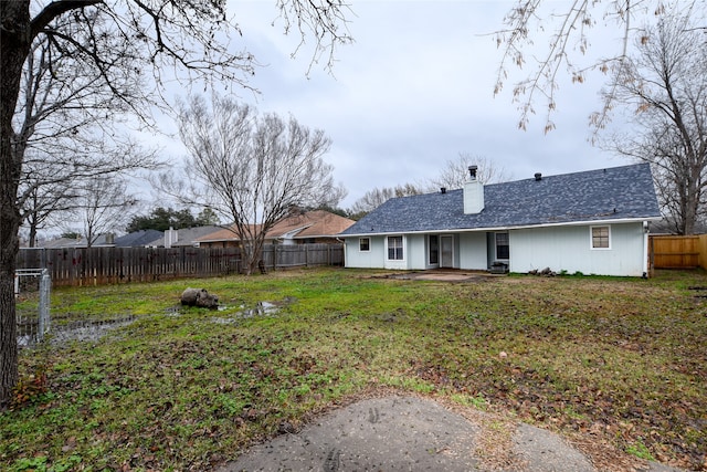 rear view of property featuring a patio and a lawn