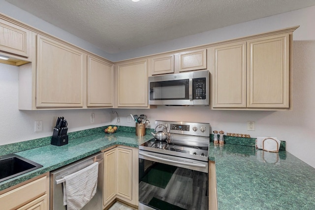 kitchen with appliances with stainless steel finishes and a textured ceiling