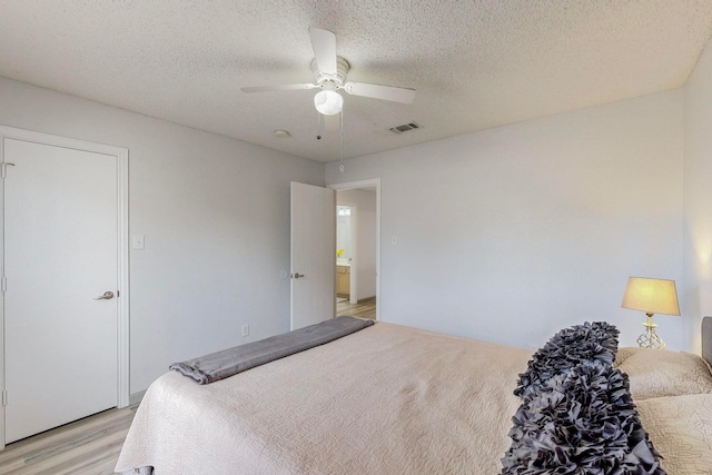 unfurnished room with ceiling fan, light wood-type flooring, and a textured ceiling