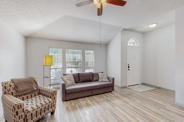 living room with light hardwood / wood-style floors, a textured ceiling, and ceiling fan