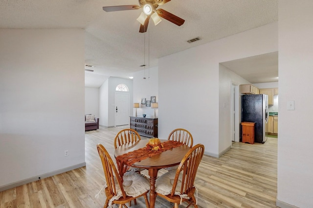 dining area featuring light hardwood / wood-style floors, a textured ceiling, and ceiling fan