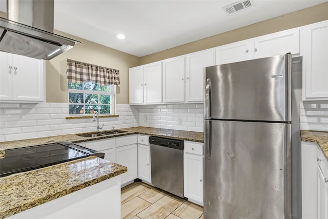 kitchen featuring dark stone countertops, white cabinetry, exhaust hood, and stainless steel appliances