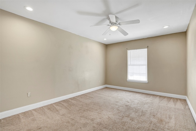 carpeted spare room with ceiling fan