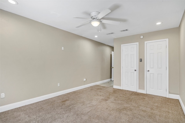 unfurnished room with ceiling fan and light carpet