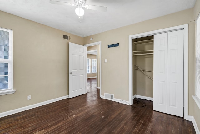 unfurnished bedroom featuring ceiling fan, dark wood-type flooring, and a closet