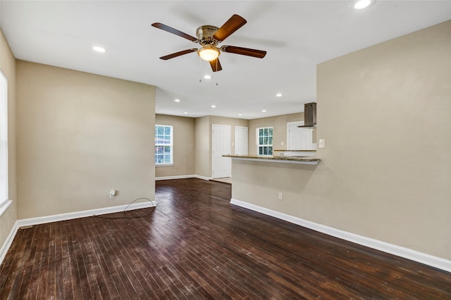 unfurnished living room with ceiling fan and dark hardwood / wood-style flooring