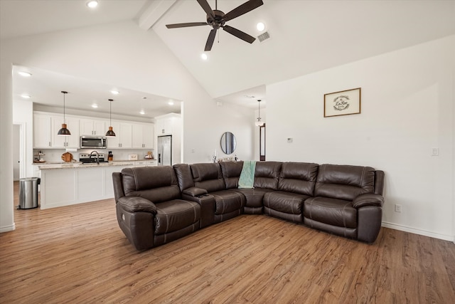 living room with ceiling fan, light hardwood / wood-style flooring, high vaulted ceiling, and beamed ceiling