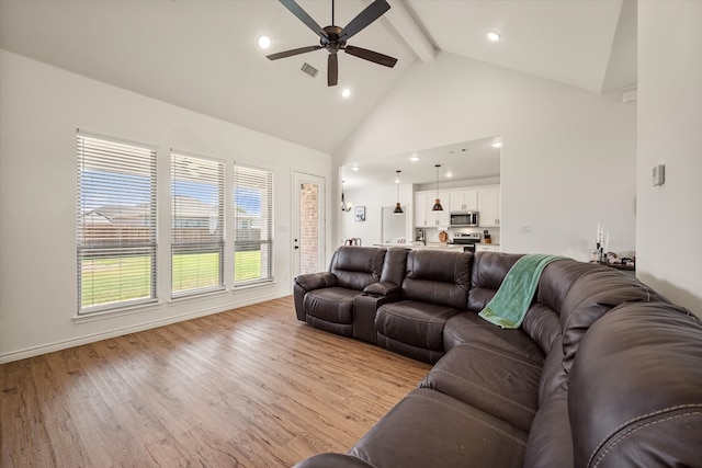 living room with ceiling fan, light hardwood / wood-style flooring, beamed ceiling, and high vaulted ceiling