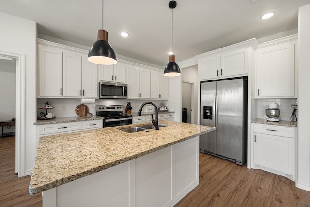 kitchen with pendant lighting, sink, white cabinets, and stainless steel appliances