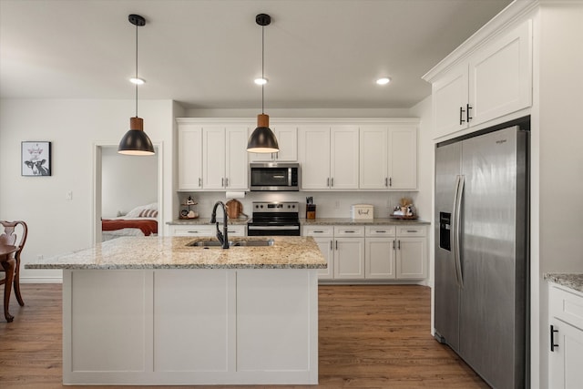 kitchen with white cabinetry, hanging light fixtures, and stainless steel appliances