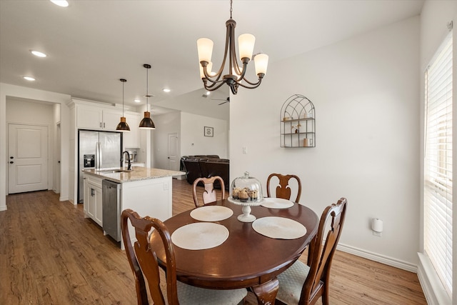 dining area featuring light hardwood / wood-style flooring, an inviting chandelier, and sink