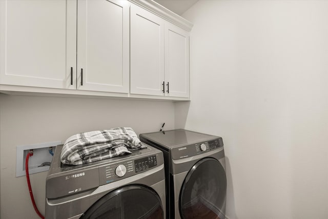 laundry area with cabinets and washer and clothes dryer