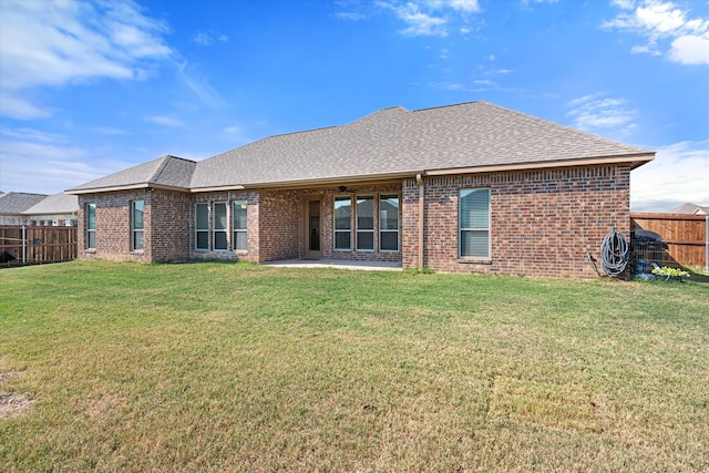 back of house featuring a lawn and a patio