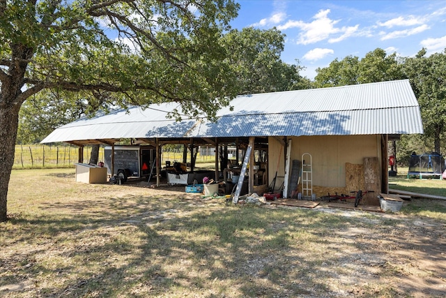 1455 County Road 2008 Unit B, Glen Rose, TX 76043 - view of front of house with a trampoline, a pole building, an outbuilding, metal roof, and a front yard