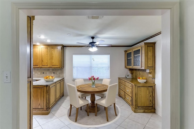 dining area with light tile patterned flooring, ornamental molding, and ceiling fan