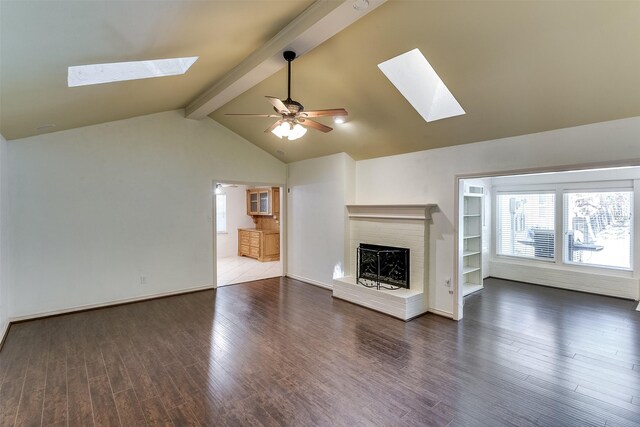 unfurnished living room featuring a fireplace, lofted ceiling with skylight, dark hardwood / wood-style floors, and a healthy amount of sunlight