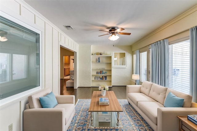 living area with visible vents, ceiling fan, and dark wood-style flooring