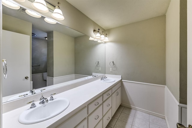 full bathroom with a sink, visible vents, double vanity, and tile patterned floors