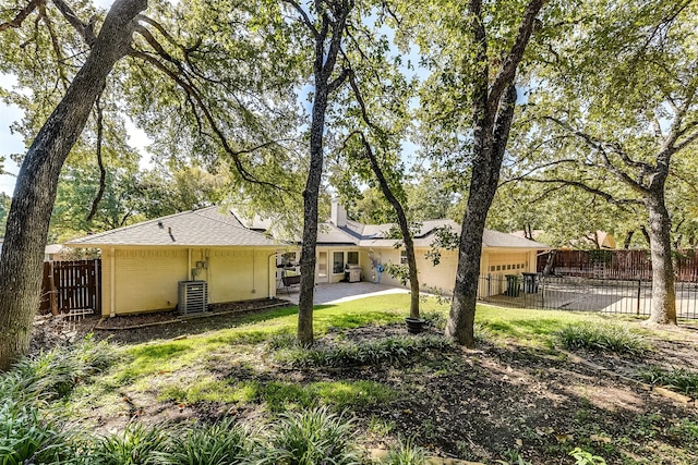 1805 Woodside Dr, Arlington, TX 76013 - back of property with fence private yard, an attached garage, a chimney, and central AC