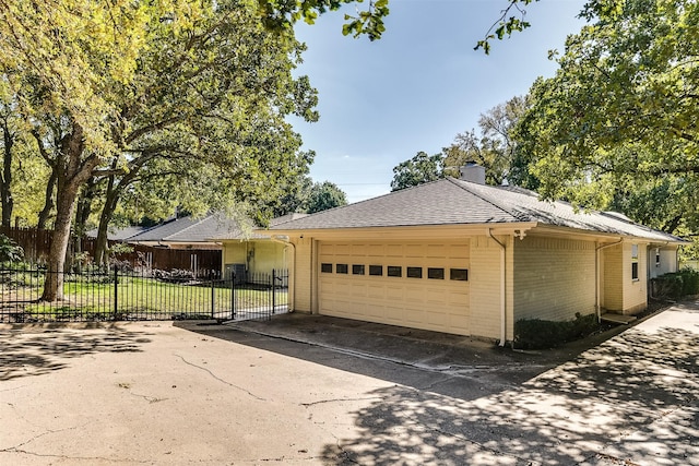 ranch-style house featuring brick siding, fence, concrete driveway, a chimney, and a garage