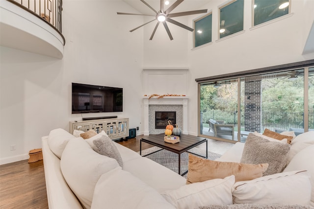 living room featuring ceiling fan, a high ceiling, and dark hardwood / wood-style flooring