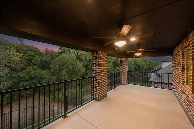 balcony at dusk featuring ceiling fan