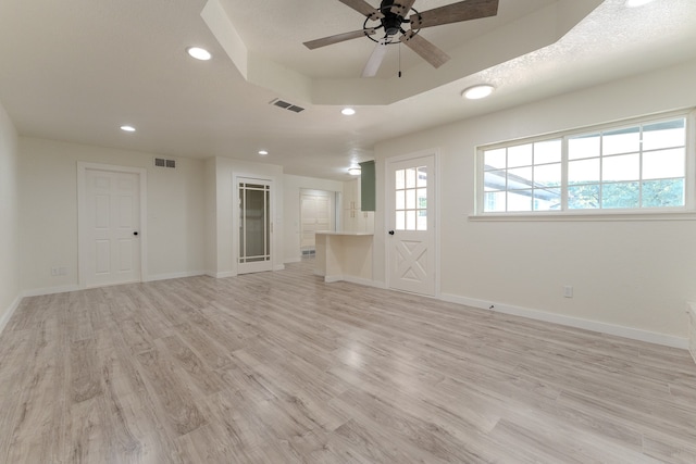 unfurnished living room featuring a textured ceiling, light wood-type flooring, and ceiling fan