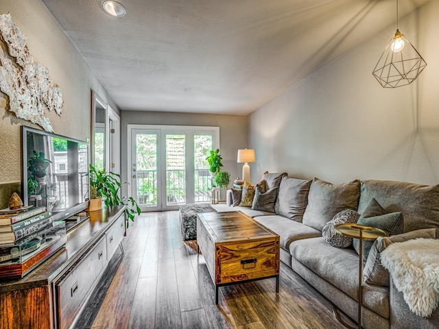 living room with french doors, a textured ceiling, and dark wood-type flooring