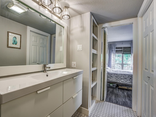 bathroom with vanity, tile patterned flooring, and a textured ceiling