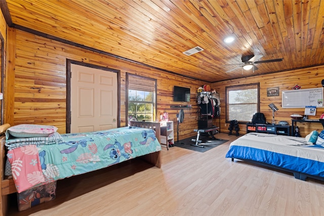 bedroom with light wood-type flooring, ceiling fan, wood walls, and wooden ceiling