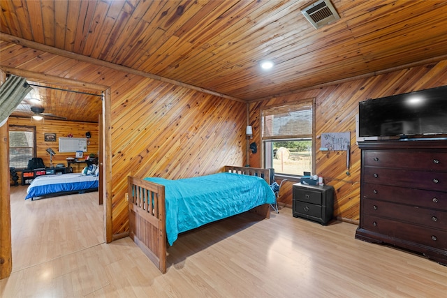 bedroom featuring wooden walls, wooden ceiling, and light hardwood / wood-style flooring