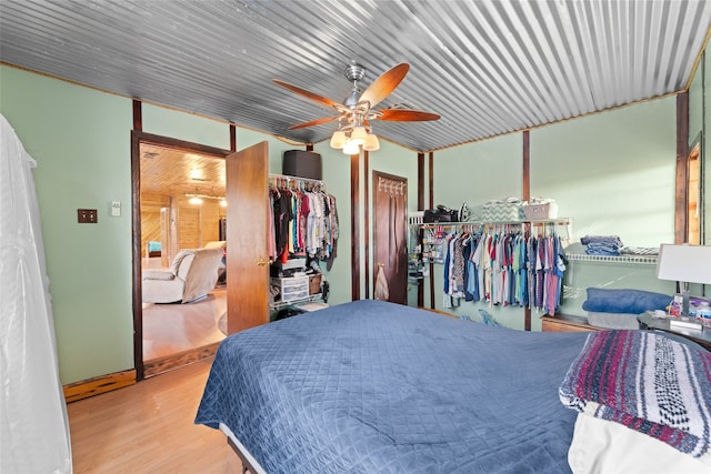 bedroom featuring ceiling fan, light hardwood / wood-style flooring, and a closet