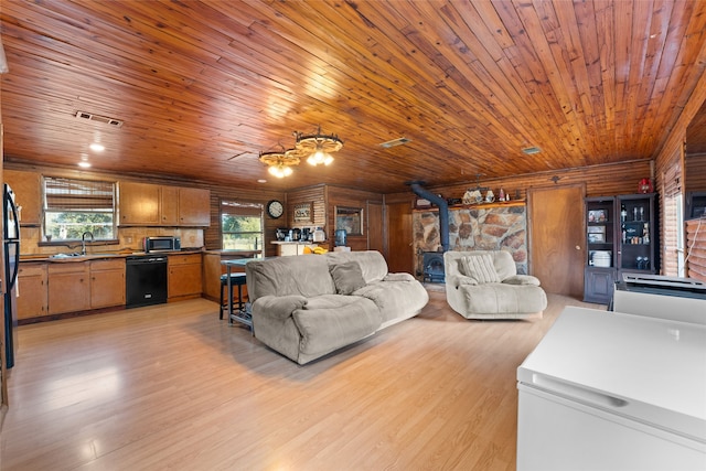 living room with a wood stove, a wealth of natural light, and wood ceiling