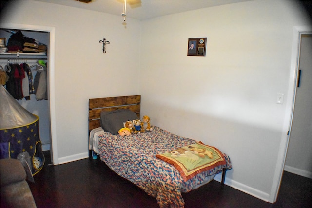 bedroom with dark hardwood / wood-style flooring, a closet, and ceiling fan