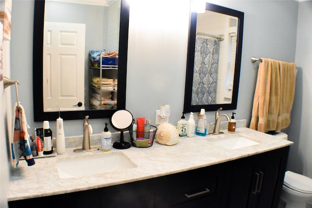 bathroom with vanity, toilet, and ornamental molding