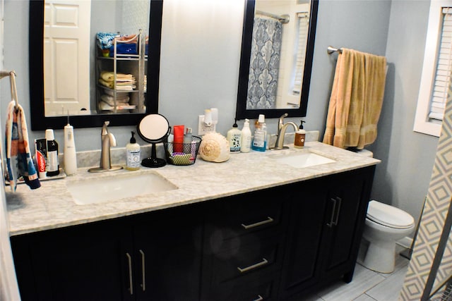 bathroom featuring tile patterned floors, vanity, and toilet