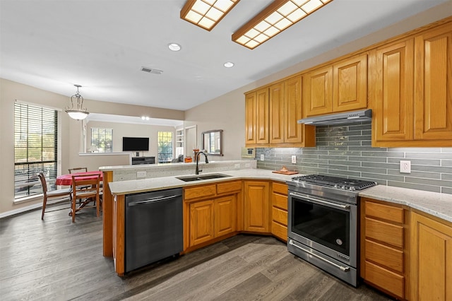 kitchen with stainless steel appliances, sink, kitchen peninsula, dark hardwood / wood-style flooring, and decorative backsplash