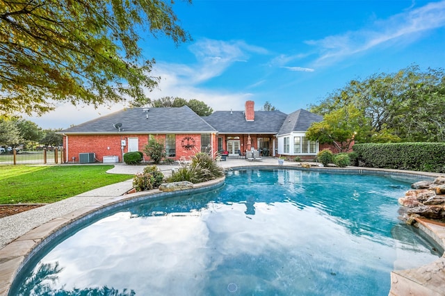 view of swimming pool featuring central air condition unit, a patio, and a yard