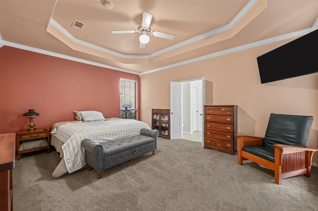 carpeted bedroom with ornamental molding, a tray ceiling, and ceiling fan