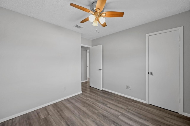 unfurnished bedroom with hardwood / wood-style flooring, ceiling fan, and a textured ceiling