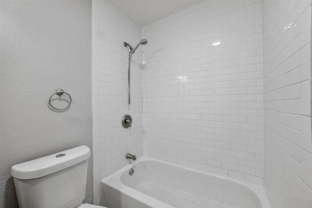 bathroom with tiled shower / bath combo and toilet