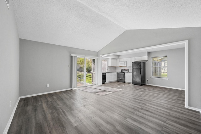 unfurnished living room featuring vaulted ceiling, dark hardwood / wood-style floors, and a textured ceiling