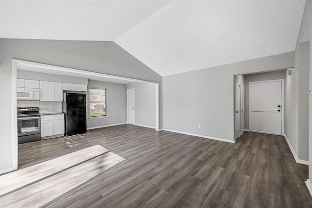 unfurnished living room featuring lofted ceiling, dark wood-type flooring, and a textured ceiling