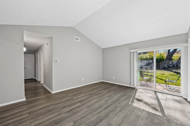 unfurnished living room with vaulted ceiling, dark wood-type flooring, and a textured ceiling