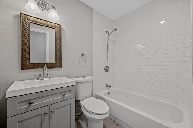 full bathroom featuring vanity, tiled shower / bath combo, and toilet