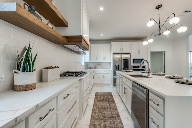 kitchen with stainless steel appliances, hanging light fixtures, sink, and white cabinetry