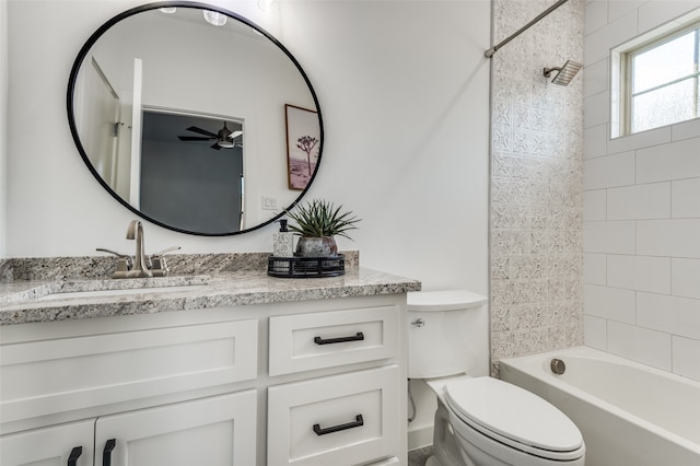 full bathroom featuring ceiling fan, vanity, toilet, and tiled shower / bath