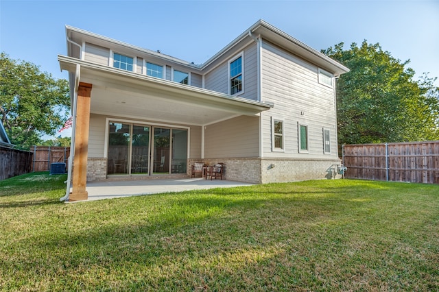 back of house with a patio and a lawn